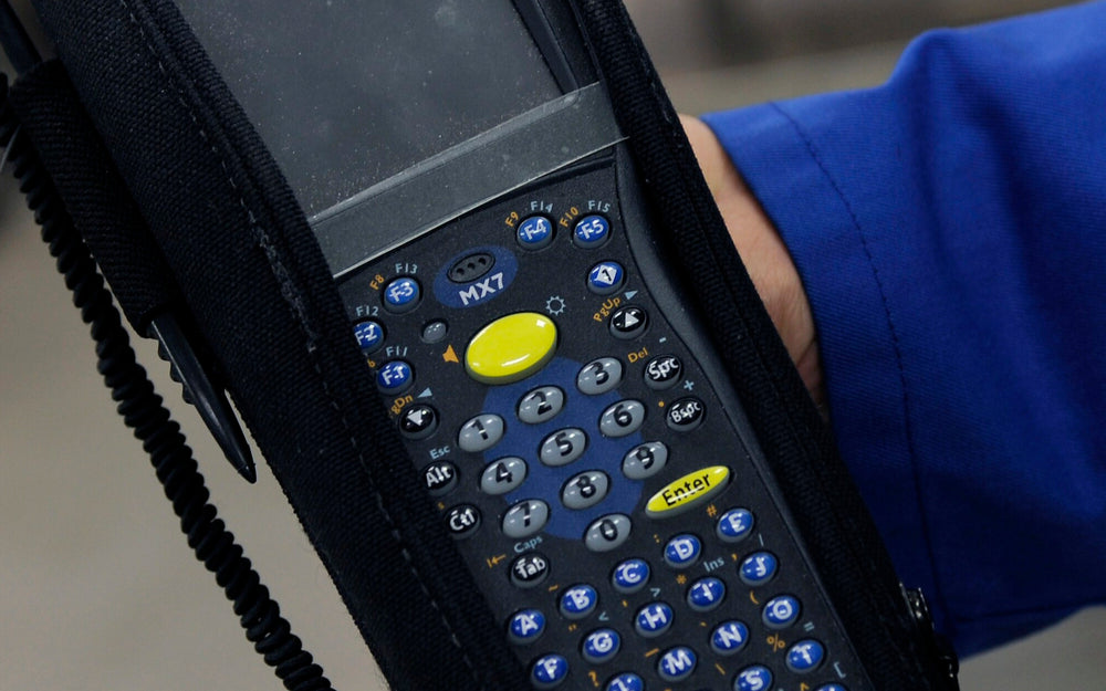 Handheld package tracker used during a documented warehouse custody handoff