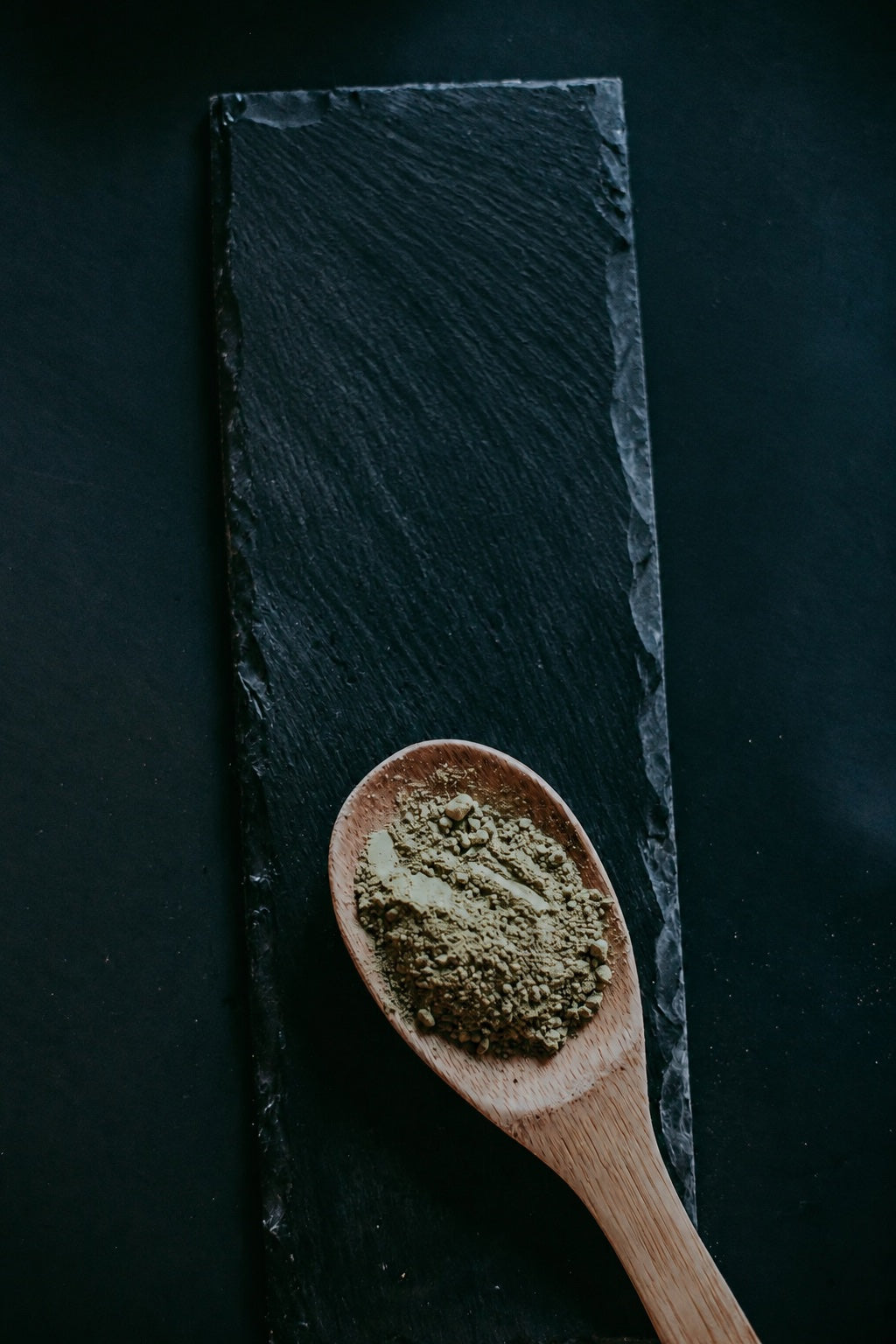 Kratom powder resting on a wooden spoon